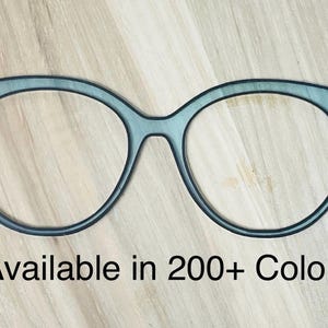 May include: A pair of black cat-eye glasses with a light blue tint. Available in 200+ colors.