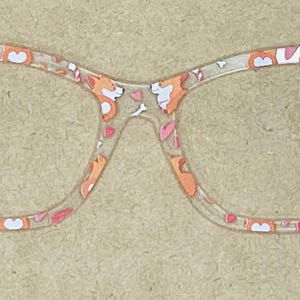 Puede incluir: Gafas de plástico transparente con un patrón de gato. Las gafas tienen un diseño de cara de gato y huella de pata.