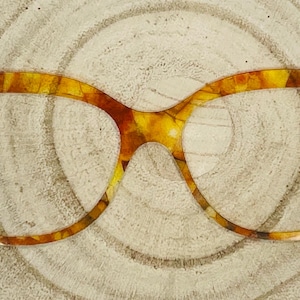 May include: Eyeglass frames featuring a glossy, multi-colored tortoiseshell pattern in shades of amber, gold, and dark brown. The frames have a distinct cat-eye shape with metallic hinges visible on the outer edges of the rims for lens attachment.