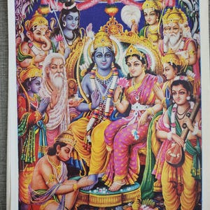 Peut inclure: Une impression vibrante et colorée représentant des divinités hindoues. Les personnages centraux sont assis sur des trônes ornés, entourés d'autres figures. L'œuvre présente des couleurs riches, des détails complexes et des vêtements traditionnels, mettant en valeur un thème religieux.