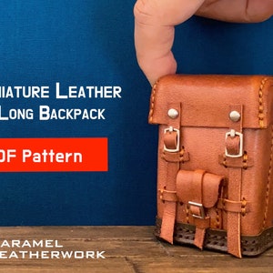 May include: A miniature brown leather backpack with buckles and stitching. The backpack is being held by a hand. The text "MINIATURE LEATHER LONG BACKPACK PDF Pattern" is displayed above the backpack. The text "KARAMEL LEATHERWORK" is displayed below the backpack.