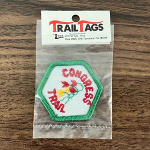 May include: A green and white embroidered patch with the text "CONGRESS TRAIL" in red lettering. The patch features a cluster of red, yellow, and white flowers.