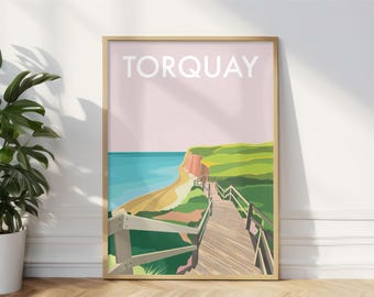 Puede incluir: Un póster enmarcado con la palabra "TORQUAY" en la parte superior. La obra de arte muestra una escena costera con una playa, el mar, acantilados y una pasarela de madera. La paleta de colores incluye rosa, verde, azul y beige.