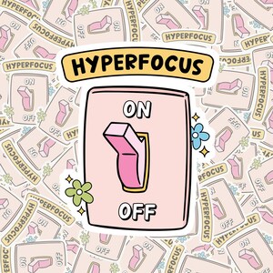 Puede incluir: Una pegatina con un interruptor rosa con las etiquetas "ON" y "OFF" y la palabra "HYPERFOCUS" encima. El fondo está lleno de pegatinas más pequeñas del mismo diseño. El interruptor tiene un contorno amarillo y detalles de flores y estrellas.