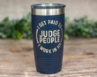 May include: A navy blue stainless steel tumbler with a gold inscription that reads "I get paid to judge people I work in HR".