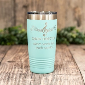 May include: A turquoise stainless steel tumbler with a silver lid. The tumbler has a musical note design and the text "Choir Director Where words fail, music speaks".