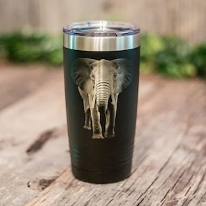 May include: A black stainless steel tumbler with a graphic of an elephant. The elephant is facing forward and has a gray and brown color scheme.