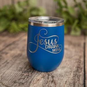 May include: A blue stainless steel tumbler with a silver lid and the text "Jesus Drank Wine" in silver lettering.