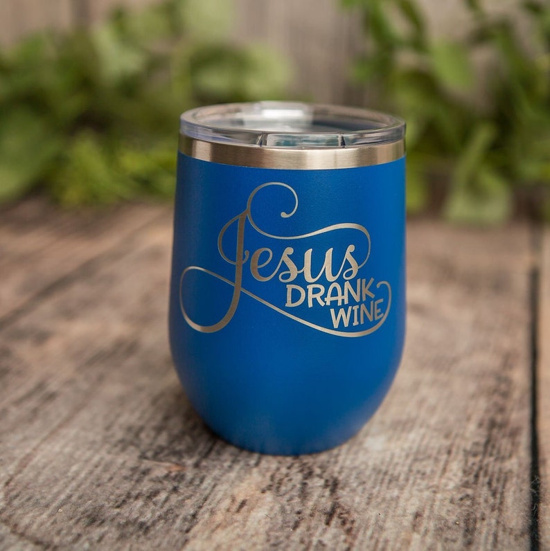 May include: A blue stainless steel tumbler with a silver lid and the text "Jesus Drank Wine" in silver lettering.