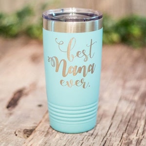 May include: A turquoise stainless steel tumbler with a silver inscription that reads "Best Nana Ever."