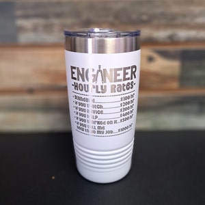 May include: White stainless steel tumbler with a black inscription that reads "Engineer - Hourly Rates -" and lists different rates for various levels of assistance. The inscription includes a compass and protractor graphic.