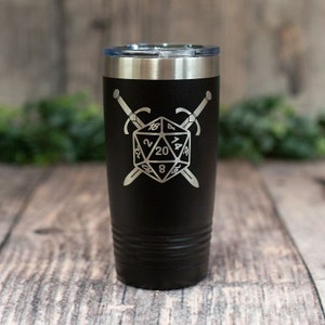 May include: Black stainless steel tumbler with a silver engraved design of a twenty-sided die with crossed swords.