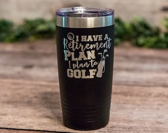 May include: Black stainless steel tumbler with a white inscription that reads "I have a retirement plan I plan to golf" with a golf ball and golf clubs graphic.