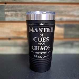 May include: Black stainless steel tumbler with a silver inscription that reads "Master of Cues and Chaos #stagecrew".
