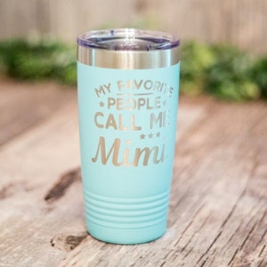 May include: A turquoise stainless steel tumbler with a silver lid. The tumbler has the text "My Favorite People Call Me Mimi" engraved on it.