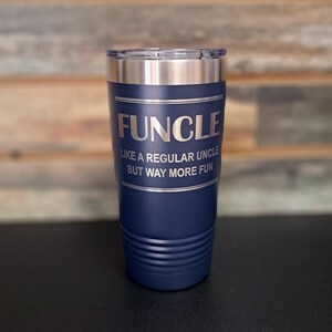 May include: A navy blue stainless steel tumbler with a silver lid. The tumbler has the text "FUNCLE LIKE A REGULAR UNCLE BUT WAY MORE FUN" engraved on the side.