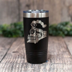 May include: Black stainless steel tumbler with a silver engraved design of a vintage steam train with smoke coming from the chimney.