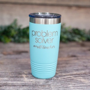 May include: A turquoise stainless steel tumbler with a silver lid. The tumbler has the text "problem solver #matheteacher" engraved on the side.