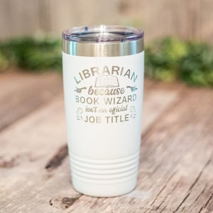 May include: White stainless steel tumbler with a silver lid. The tumbler has the text "LIBRARIAN because BOOK WIZARD isn't an official JOB TITLE" printed on it.