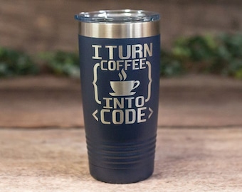May include: A navy blue stainless steel tumbler with a silver lid. The tumbler has the text "I turn coffee into code" engraved on it, with a stylized coffee cup and code brackets.