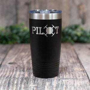May include: Black stainless steel tumbler with a silver lid and the words "PILOT" and a drone graphic engraved on the side.