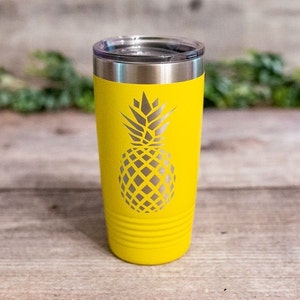 May include: A yellow stainless steel tumbler with a pineapple design. The tumbler has a lid and is insulated.