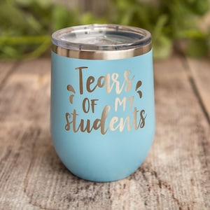 May include: A light blue stainless steel tumbler with a silver lid. The tumbler has the text "Tears of my students" printed on it.