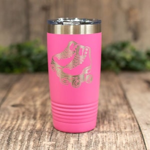 May include: A pink stainless steel tumbler with a laser engraved design of a pair of roller skates.