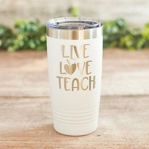 May include: White stainless steel tumbler with a gold inscription that reads "Live Love Teach" with an apple and heart graphic.