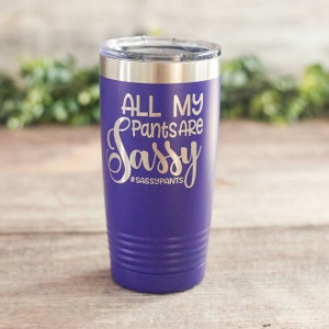 May include: Purple stainless steel tumbler with a silver lid. The tumbler has the text "All My Pants Are Sassy #SASSYPANTS" engraved on the side.