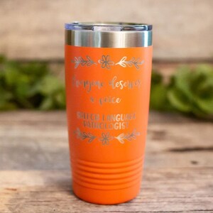 May include: Orange stainless steel tumbler with the text "Everyone deserves a voice Speech Language Pathologist" in silver lettering.