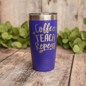May include: A purple stainless steel tumbler with the text "Coffee Teach Repeat" and a small arrow graphic.
