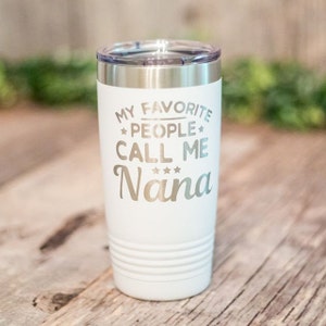 May include: White stainless steel tumbler with a silver lid. The tumbler has the text "My Favorite People Call Me Nana" with three stars above the word "Nana".