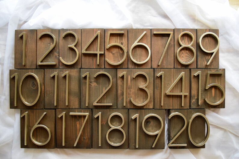 Puede incluir: Veinte bloques de madera con n&uacute;meros dorados del 1 al 20. Los n&uacute;meros est&aacute;n en relieve y tienen un dise&ntilde;o moderno y minimalista.