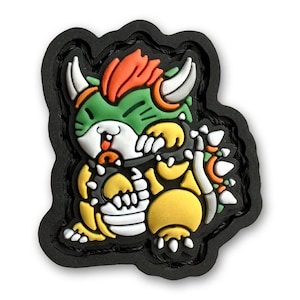 May include: A green, yellow, and orange cartoon character with a spiky shell and horns. The character is wearing a black mask and has a red tongue sticking out. The character is on a black background.