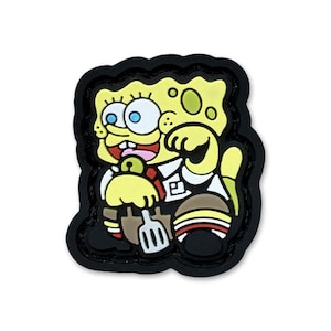 May include: A rubberized patch featuring a yellow, porous character with large blue eyes, a wide smile, and a white collared shirt. The character holds a silver spatula and wears brown shorts with striped socks, all outlined in a thick black border.