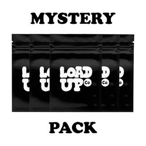 Puede incluir: Un 'Mystery Pack' negro con las palabras 'MYSTERY' y 'PACK' en letras blancas en negrita. El paquete contiene varias bolsas negras con el texto blanco 'LOAD UP Co.'