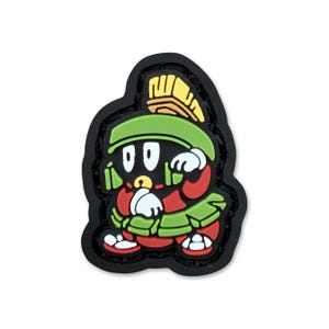 May include: A colorful cartoon character patch featuring Marvin the Martian. The patch has a black border and depicts Marvin in his signature green helmet, red suit, and white gloves. The design includes yellow, white, and red accents.