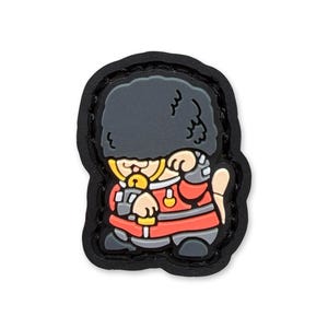 May include: A cartoon-style patch featuring a British Royal Guard in a red uniform and black bearskin hat. The patch has a black border and is designed with a playful, stylized aesthetic. The guard is holding a sword.
