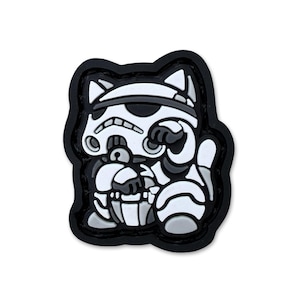 May include: A black, white, and gray patch featuring a cartoon cat in a Stormtrooper helmet. The cat is in a seated position with one paw raised. The patch has a black border and is on a white background.