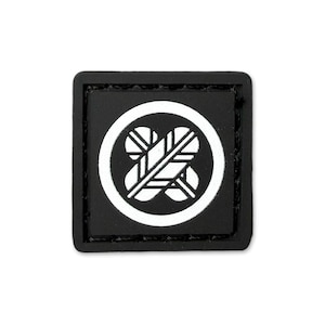 May include: A square, black patch featuring a white circular design with a stylized floral or leaf motif. The design is centered within the circle, and the patch has a stitched border.