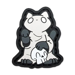 Könnte beinhalten: Ein weiß-grauer Cartoon-Katzenaufnäher mit einem Totenkopf, schwarz umrandet. Die Katze hält einen Totenkopf mit ihren Pfoten. Der Aufnäher hat einen schwarzen Rand.
