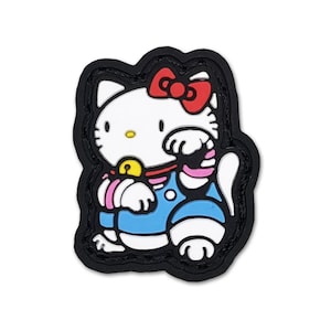 Puede incluir: Un parche colorido con un gato de dibujos animados con un lazo rojo, que lleva un atuendo azul con detalles en rosa. El gato tiene una campana dorada y está sobre un borde negro. El diseño es un personaje popular.