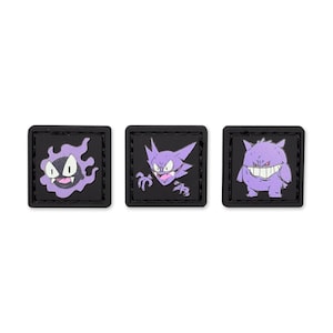 May include: Three square patches with cartoon characters in purple, each with a black border. The characters are a ghost, a bat-like figure, and a smiling monster. The patches are displayed on a white background.