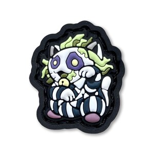 May include: A black and white skeleton cat with green hair and purple eyes. The cat is wearing a black and white striped outfit and has a pink nose. The cat is sitting on a black background.