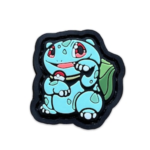 May include: A blue and green cartoon character with red eyes and a yellow and red ball in its hand. The character is a patch with a black border.