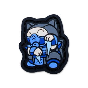 May include: A cartoon patch depicting a cat character in a blue and grey outfit with a mask, holding a piece of ice. The patch has a black border and is set against a white background.