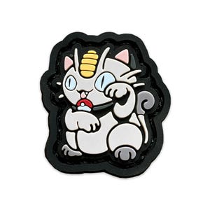 May include: A black and white cartoon patch of a cat-like Pokemon character with a yellow horn and a red Pokeball. The patch is made of rubber and has a black border.