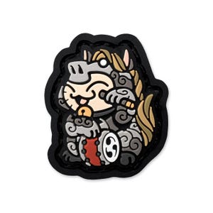 May include: A cartoon patch depicting a smiling horse-like figure with a bell, drum, and stylized mane. The design uses grey, tan, and red hues, framed by a black, irregular border. The patch is likely made of rubber or a similar material.