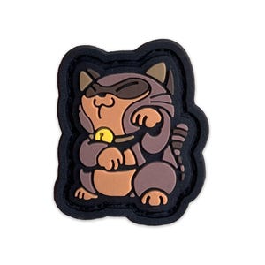 May include: A brown and black cartoon cat with a gold bell around its neck. The cat is wearing a black mask and has its paws raised in a gesture of good luck. The cat is on a black background.
